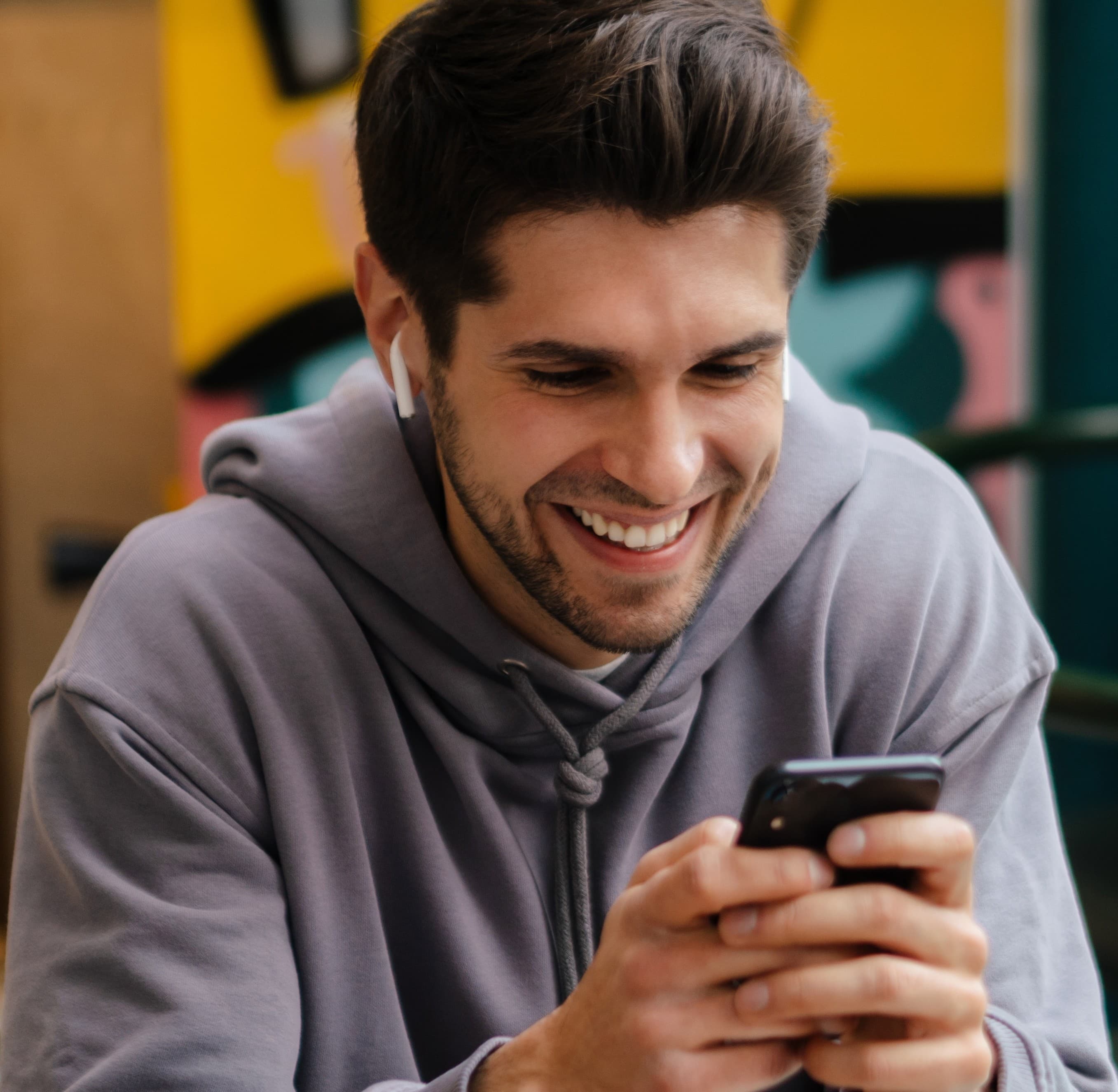 איש מחייך ומביט בטלפון